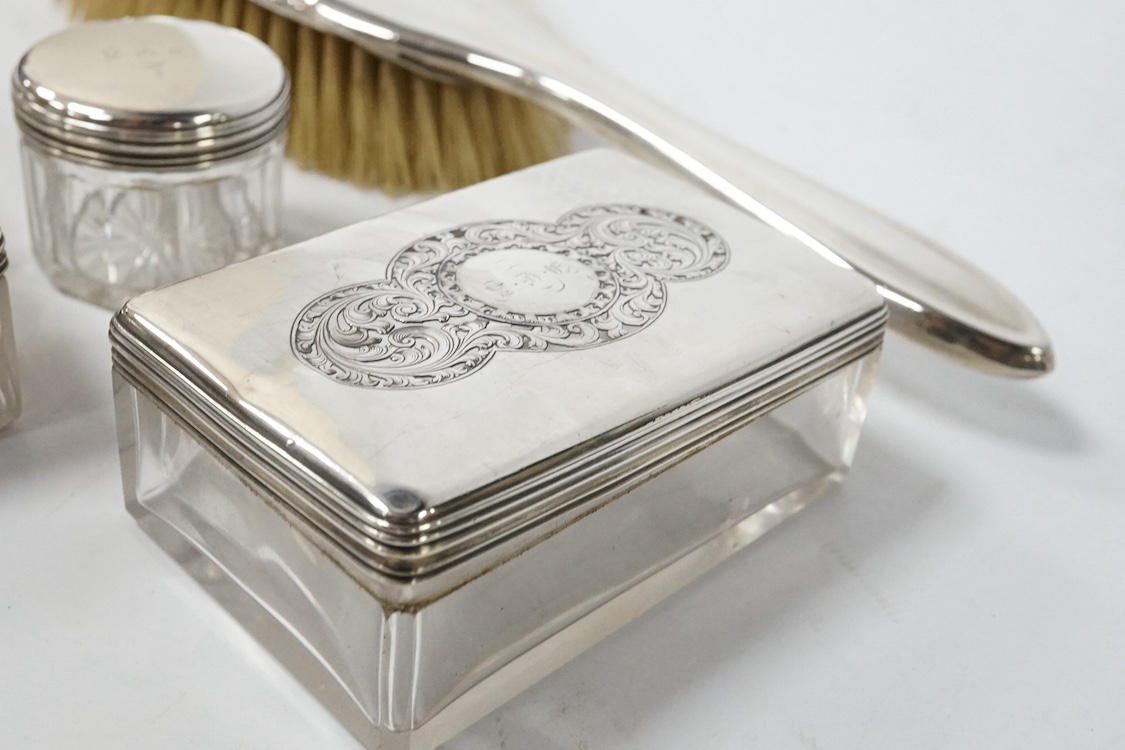 A 19th century Dutch white metal octagonal vinaigrette, with engraved geometric decoration, 51mm, together with two William IV silver mounted glass toilet jars, George Reid, London, 1834, one other later silver mounted g